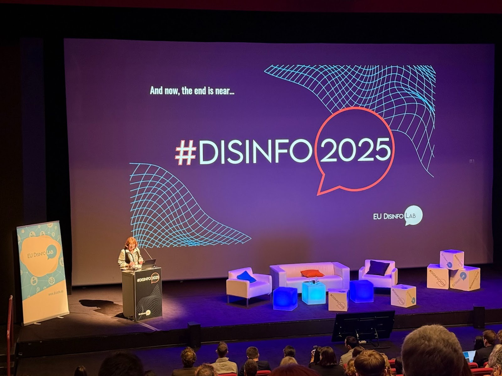 ENCODE researchers conducting biometric research on political content using a laptop, with project and ASM banners in the background.